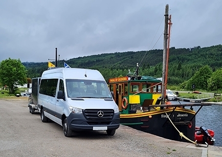 A white Mercedes-Benz Sprinter minibus parked by the Caledonian Canal in Scotland