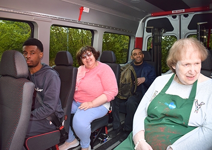 A group of people sitting in the back of an accessible minibus