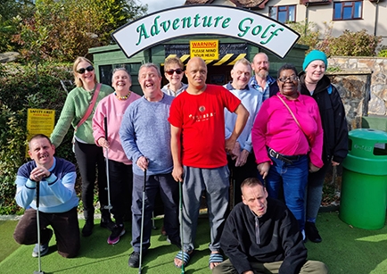 A group of people playing mini golf.