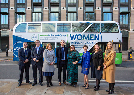 A bus parked on a road in Westminster with a group of people standing in front of it.